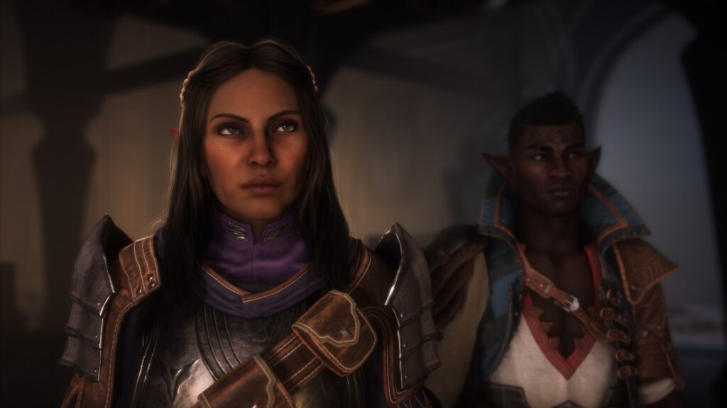 Uma protagonista élfica de armadura e cabelo preso e um companheiro elfo olham para a frente num salão escuro, em cena de Dragon Age: The Veilguard