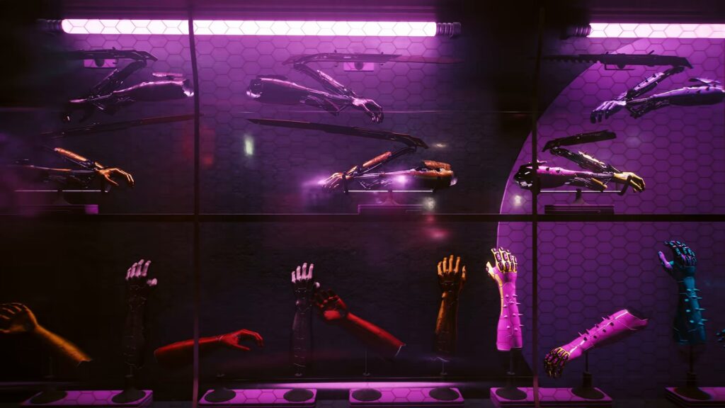 Vitrine iluminada de rosa com braços cibernéticos com lâminas Mantis Blades e mãos de metal em várias cores, numa loja Glamdoc, em cena do vídeo oficial da atualização 2.5 de Cyberpunk 2077