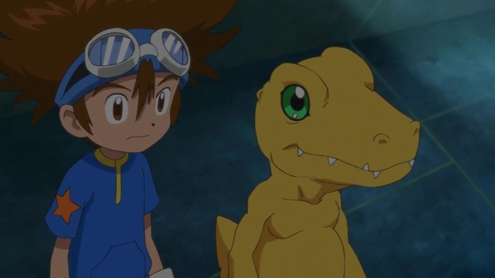 Tai (Taichi Kamiya) ao lado de Agumon em Digimon Adventure
