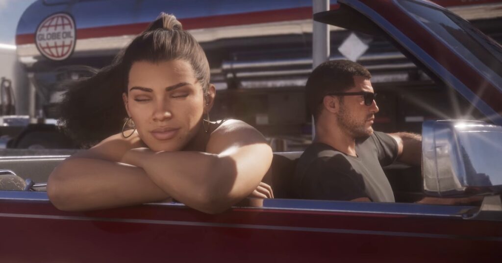 Cena oficial do trailer de lançamento de GTA 6: Lucia Caminos debruçada na porta de um conversível vermelho, com Jason Duval de óculos escuros ao volante e um caminhão da Globe Oil ao fundo