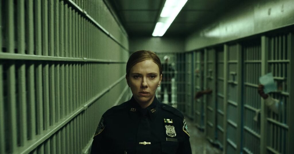 Scarlett Johansson de uniforme da polícia de Nova York num corredor de celas em O Exorcista: Mártires