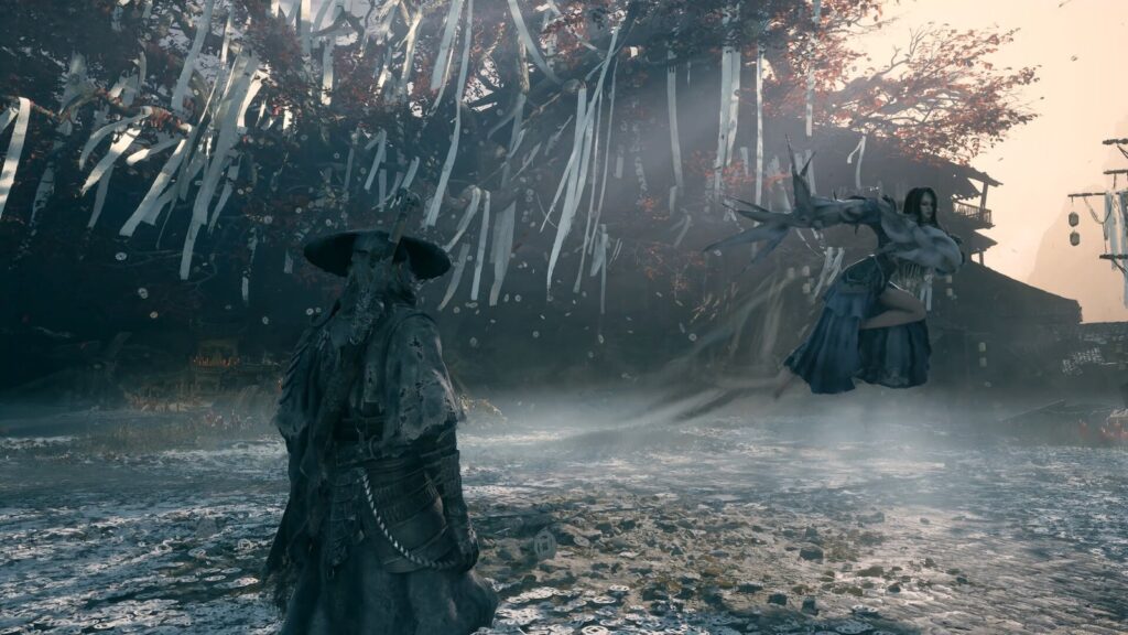 Soul, de costas e de chapéu, encara uma inimiga que flutua com garras longas sob uma árvore coberta de fitas brancas, em screenshot oficial de Phantom Blade Zero